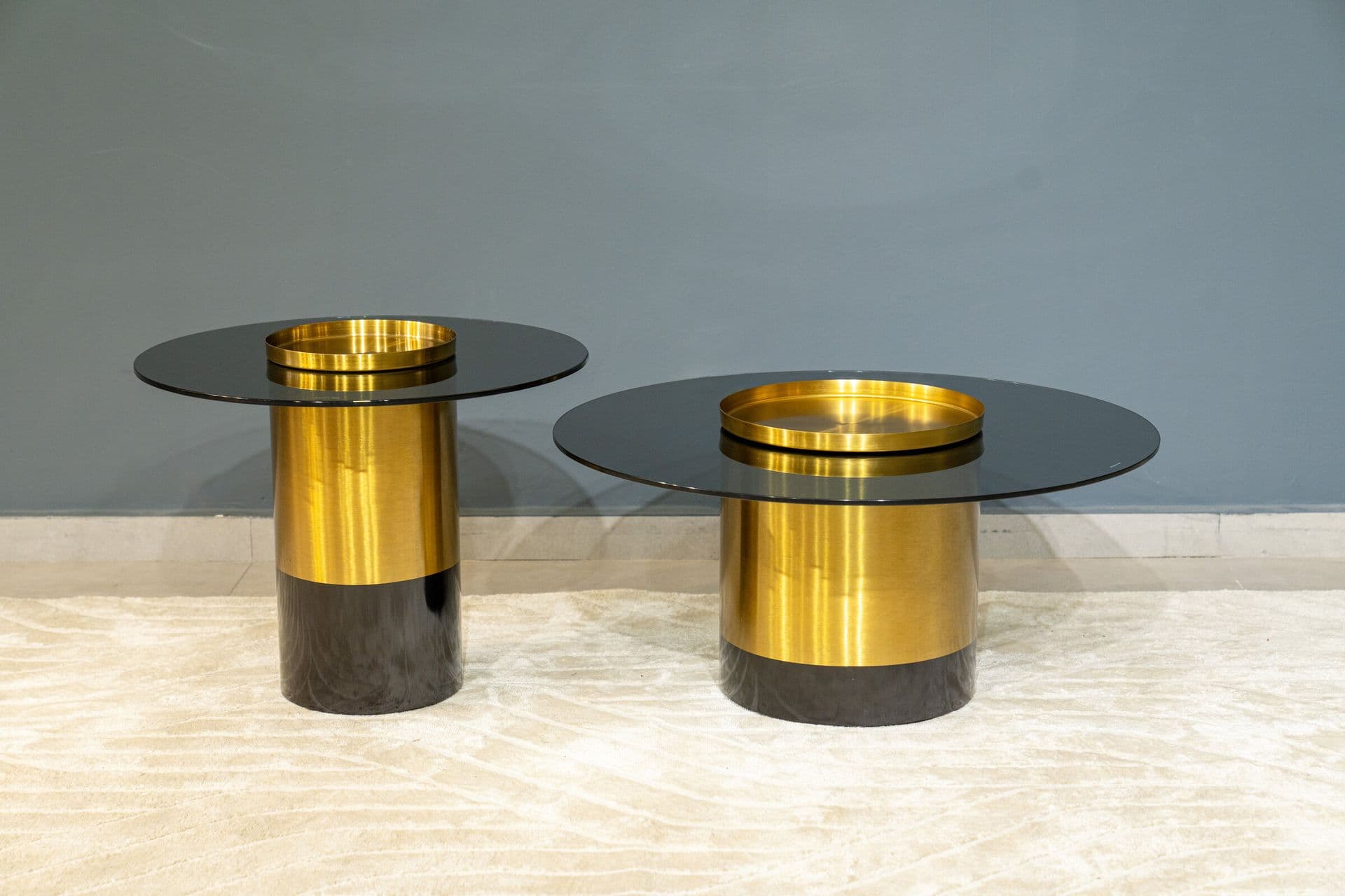 Tables basses rondes en verre fumé à piètement laiton et noir
