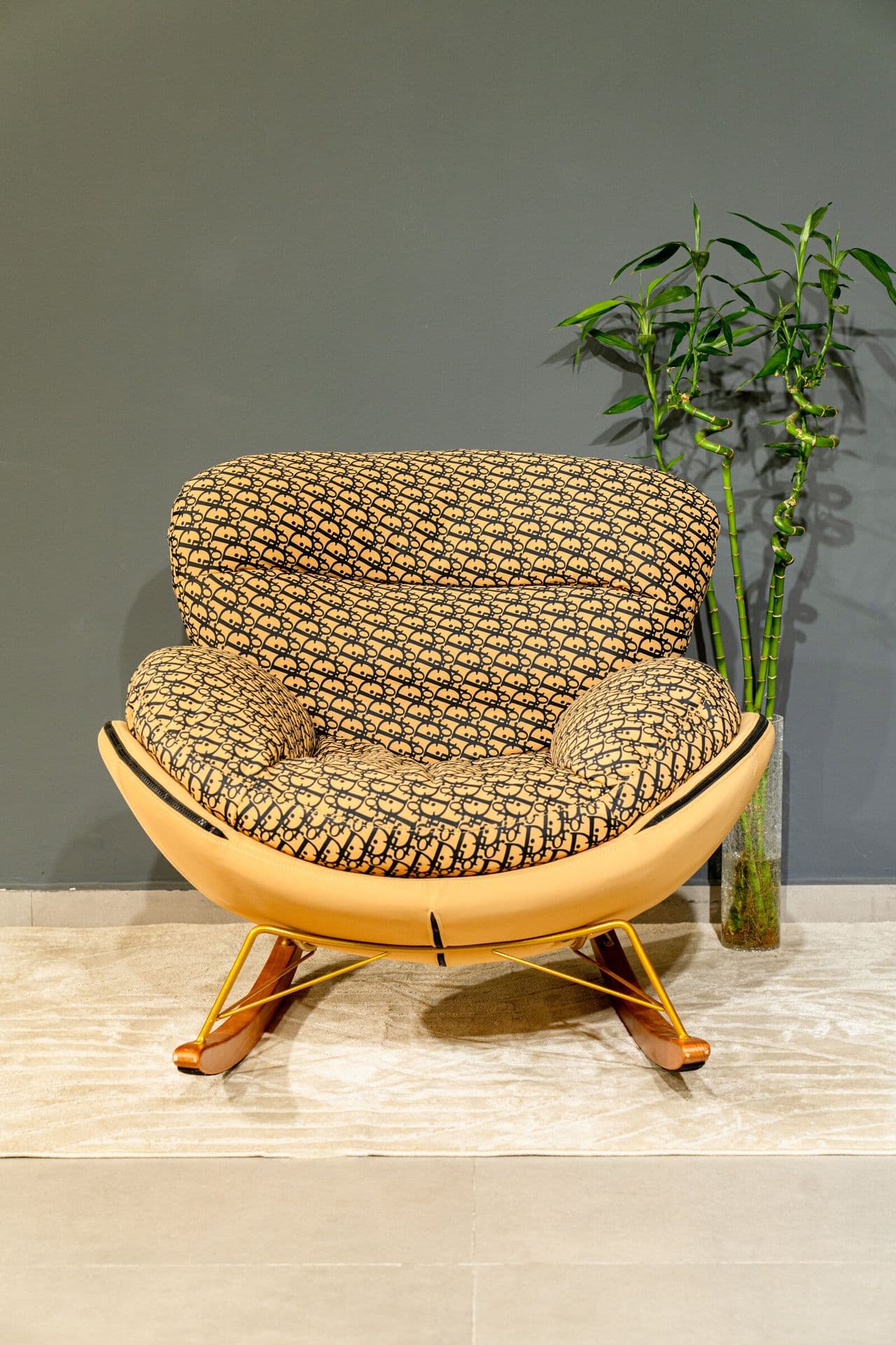 Fauteuil à bascule coque en cuir camel et coussins imprimés